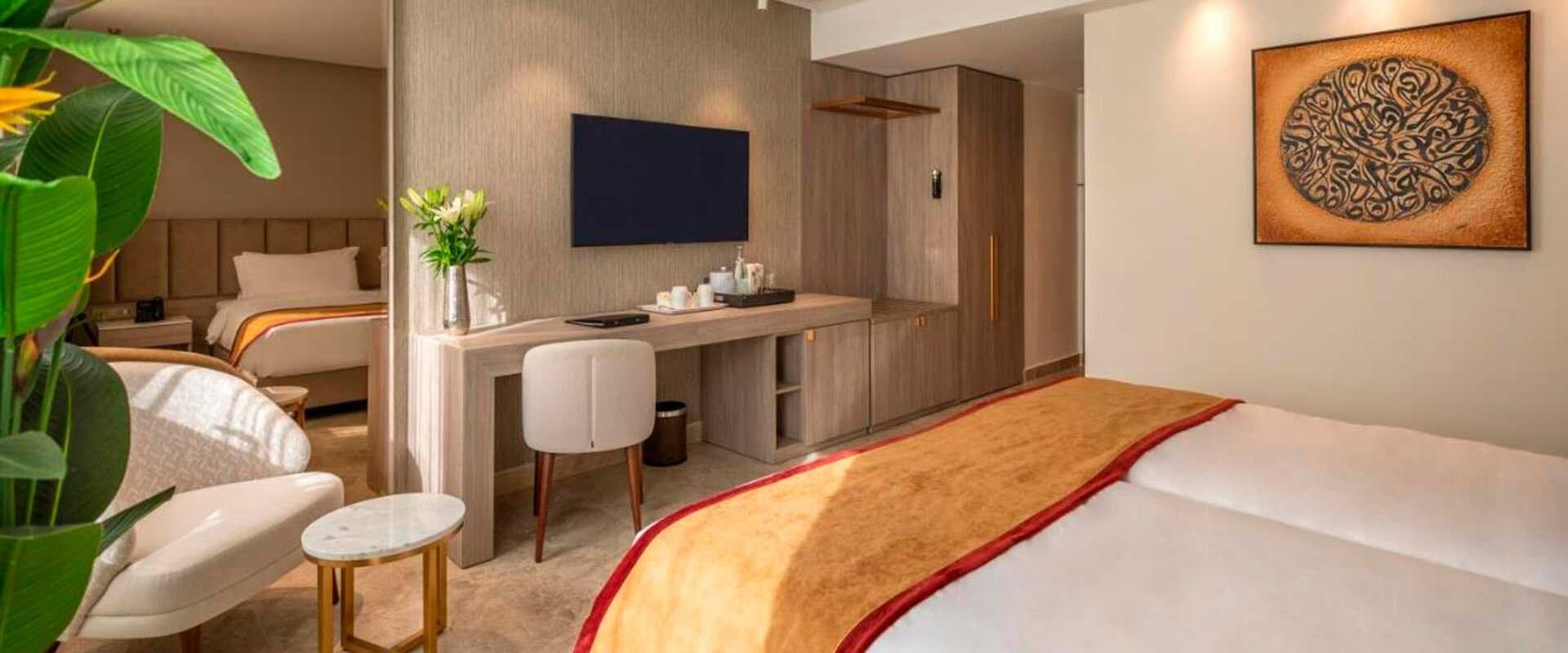 Habitación de hotel con sillón reclinable y cama articulada junto a la ventana