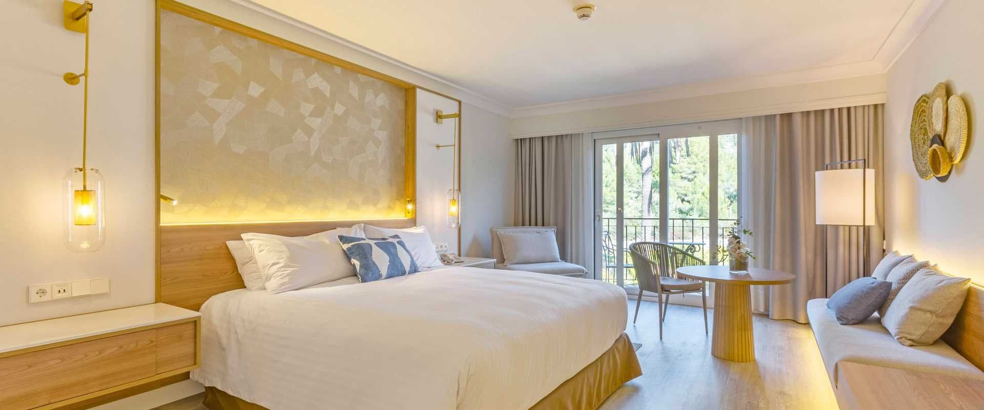 Bar de hotel con lámparas colgantes azules, sofá tapizado y taburetes altos junto a la barra