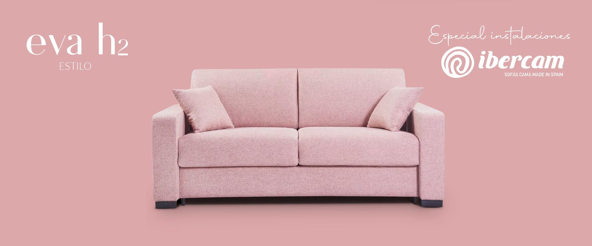 Sofá cama tapizado en rosa sobre fondo rosa junto al logotipo de la marca Ibercam