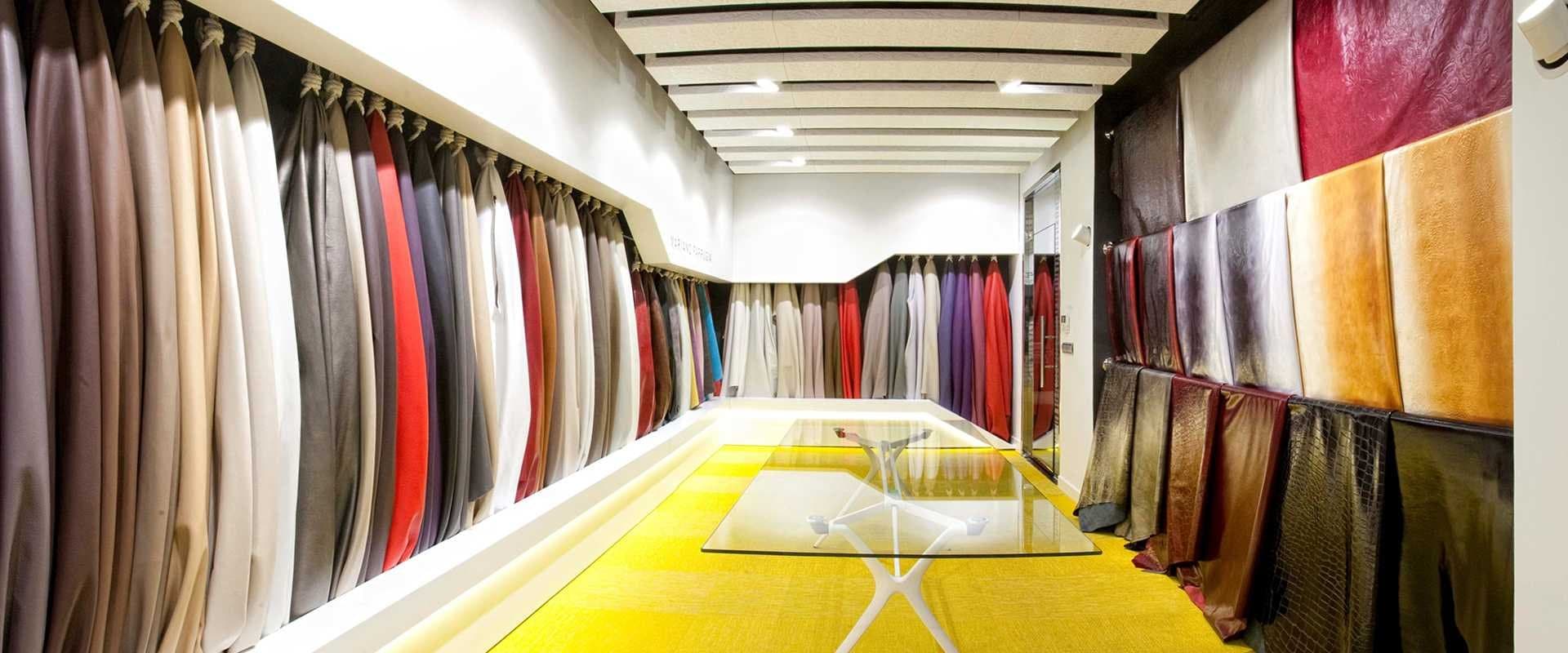Muestrario de telas y cueros de tapicería colgados en una sala de exposición