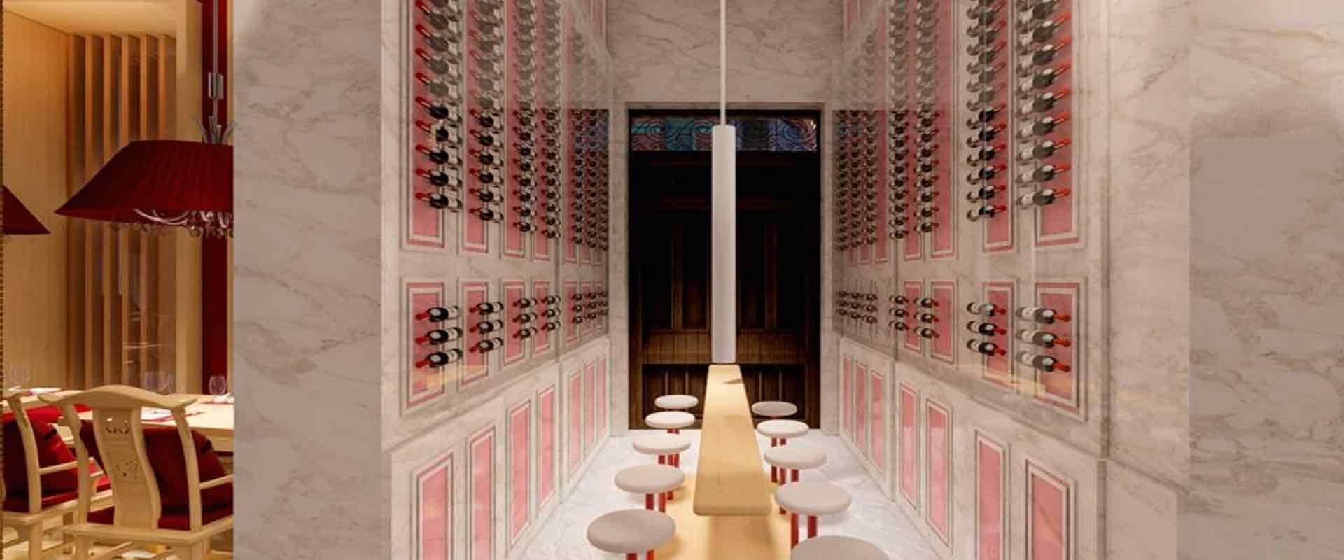 Pasillo revestido de mármol con estanterías de botellas de vino iluminadas y mesa alta con taburetes