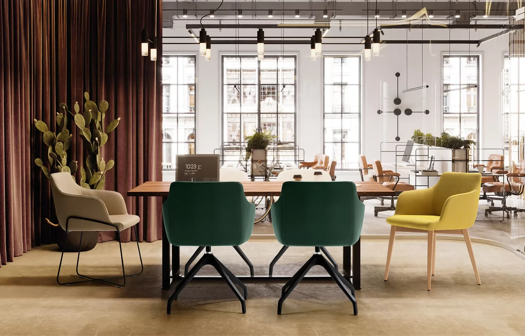 Sala de reuniones con sillas tapizadas en verde, amarillo y crudo alrededor de una mesa de madera