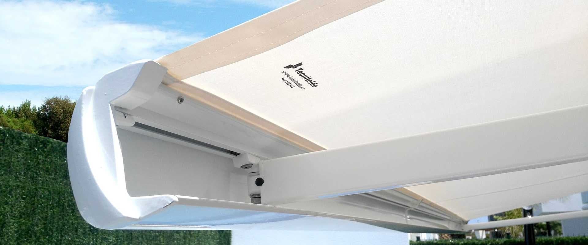 Detalle de un toldo retráctil extendido con el logotipo de la marca Tecnitoldo