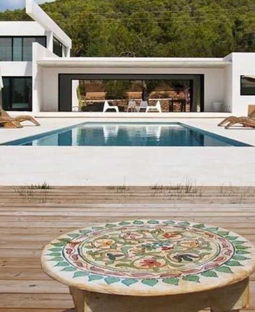 Vivienda con piscina exterior y terraza de madera