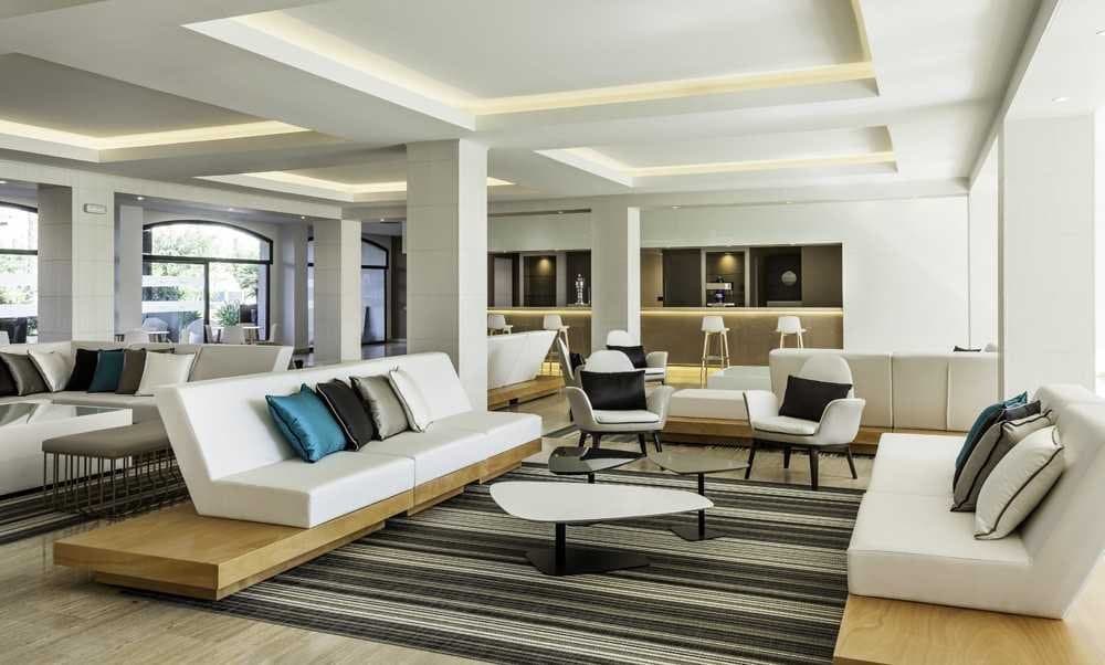 Lobby de hotel con sofás, sillones y mesas bajas