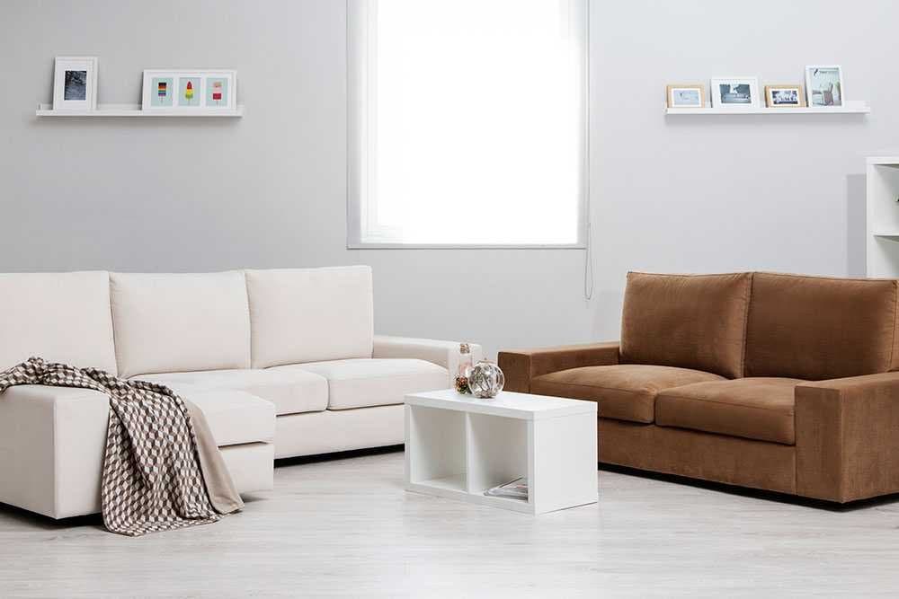 Sofá chaise longue en color crudo y sofá en tono marrón junto a una mesa baja
