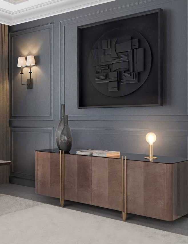 Aparador de madera con detalles dorados bajo un panel decorativo geométrico negro en la pared