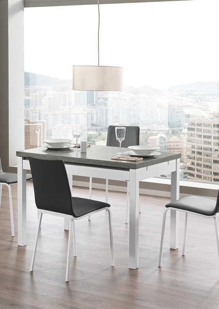 Mesa de comedor extensible en gris y blanco con sillas tapizadas junto a un ventanal con vistas a la ciudad