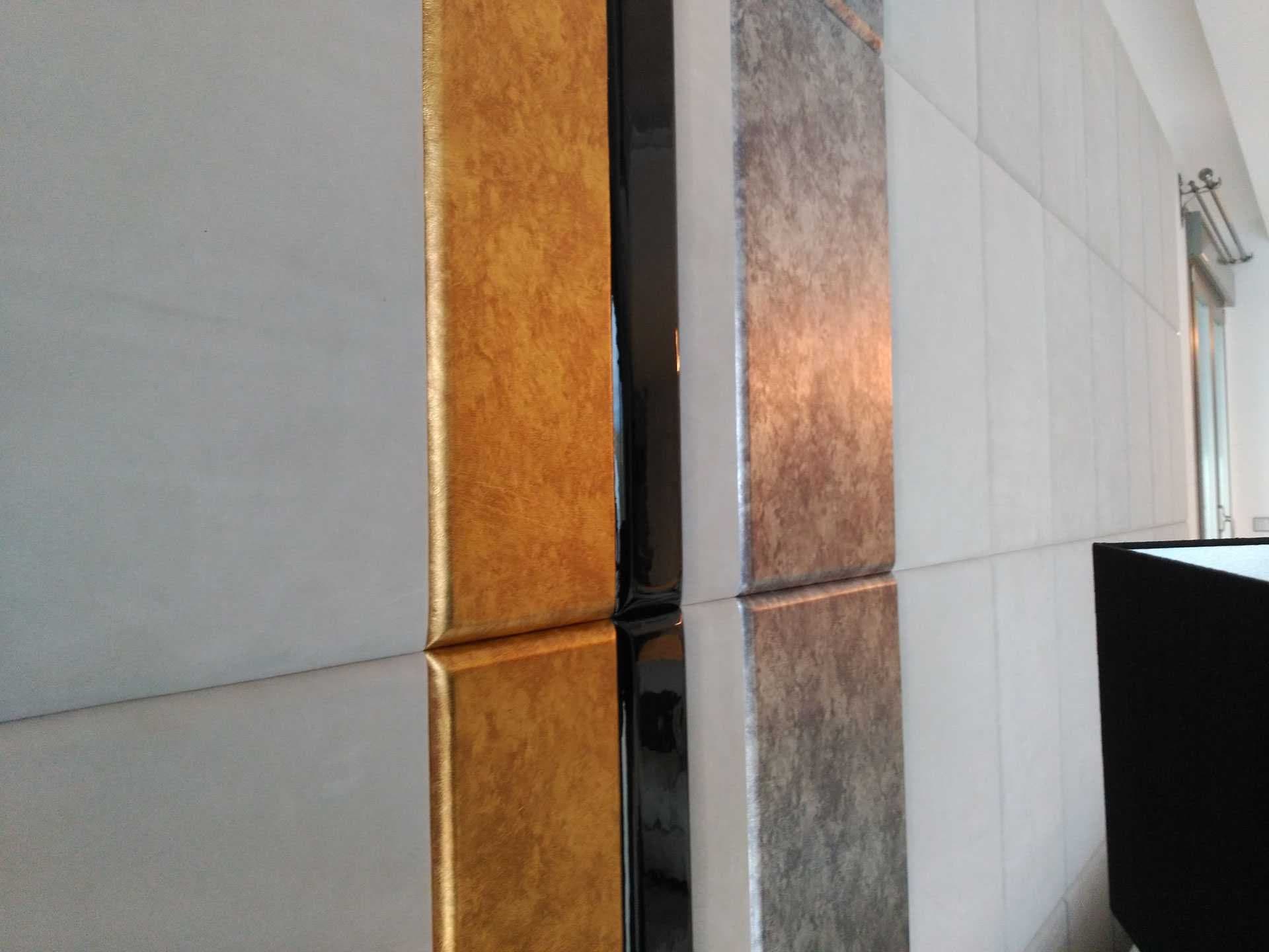 Detalle de esquina de panel decorativo con acabados en dorado, negro y plata metalizado